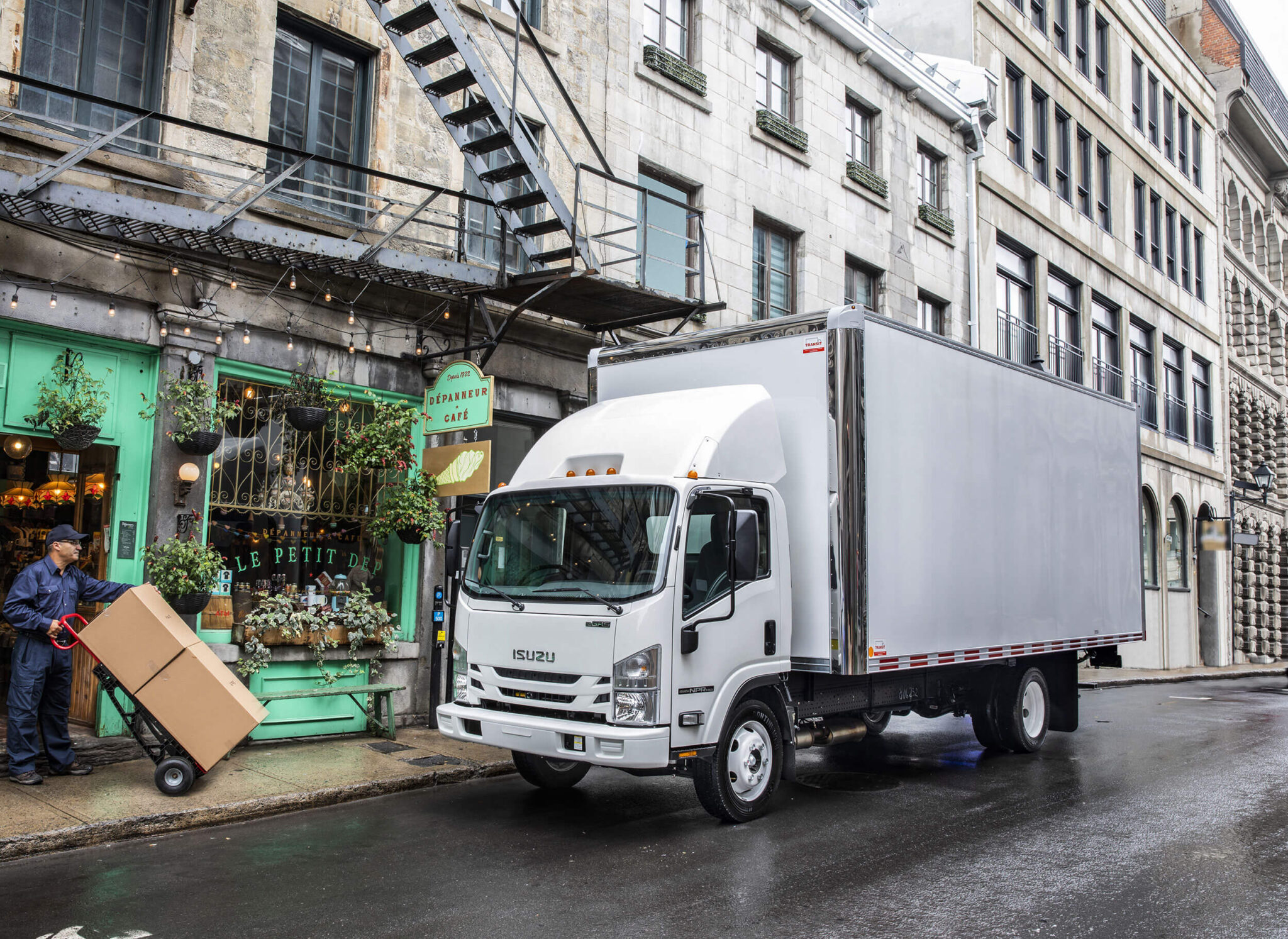 Isuzu delivery truck outside a city florist's shop.