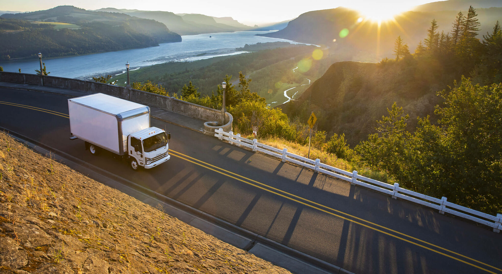 Isuzu truck driving in the mountains at dusk.