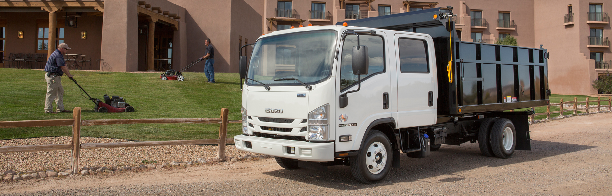 Landscaping crew at work next to their Isuzu truck.